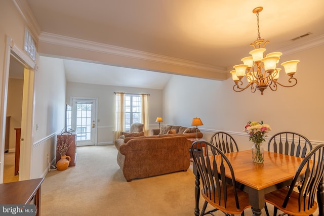 carpeted dining space with an inviting chandelier and crown molding