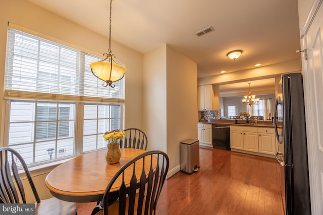 dining space featuring sink, a chandelier, and hardwood / wood-style floors