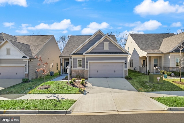 craftsman house with a front yard, cooling unit, concrete driveway, a garage, and brick siding