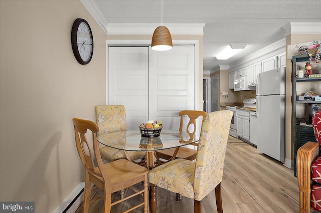 dining area featuring crown molding and light wood-type flooring