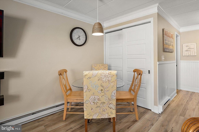 dining room featuring light hardwood / wood-style flooring, crown molding, and a baseboard radiator