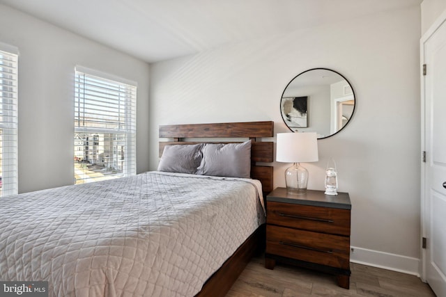 bedroom with baseboards and wood finished floors