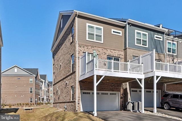 exterior space featuring a garage, driveway, and brick siding