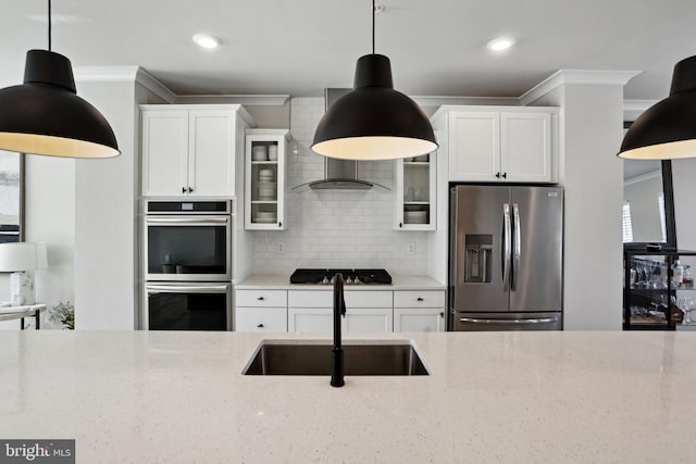 kitchen featuring backsplash, appliances with stainless steel finishes, glass insert cabinets, a sink, and light stone countertops