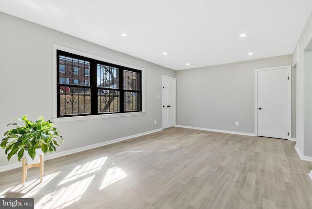 empty room with recessed lighting, baseboards, and light wood finished floors