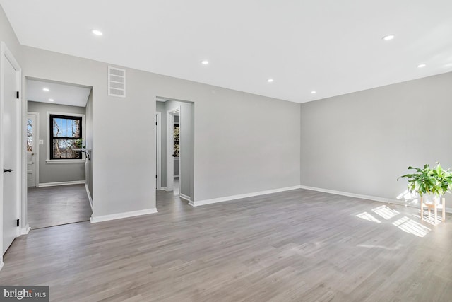 unfurnished room featuring recessed lighting, visible vents, light wood-style flooring, and baseboards