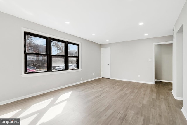 spare room featuring recessed lighting, baseboards, and light wood-style floors