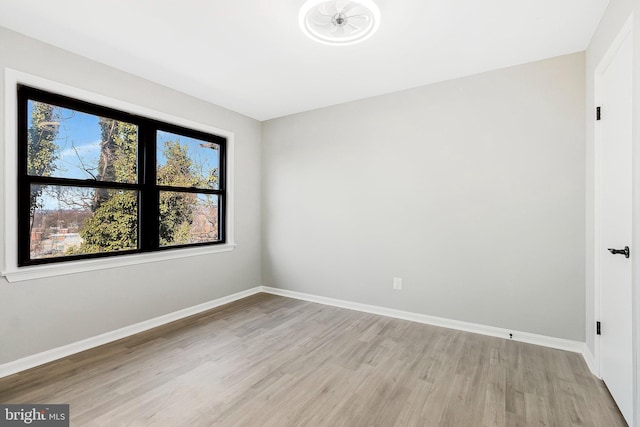 spare room with light wood finished floors and baseboards