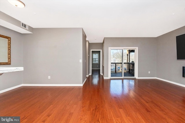 unfurnished living room featuring a fireplace, wood finished floors, visible vents, and baseboards