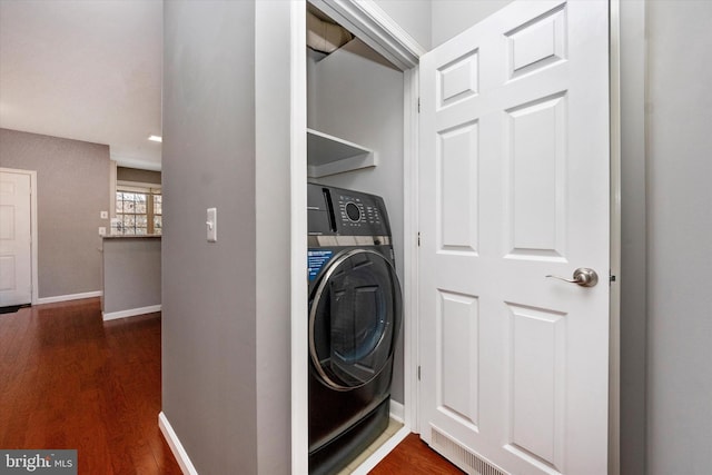 laundry area featuring laundry area, baseboards, washer / clothes dryer, and dark wood finished floors