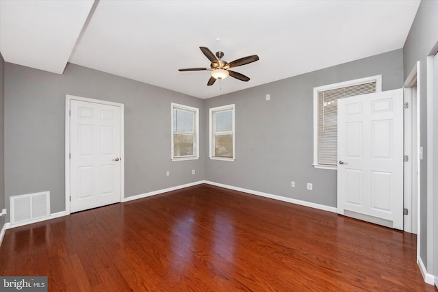 unfurnished bedroom featuring a ceiling fan, wood finished floors, visible vents, and baseboards