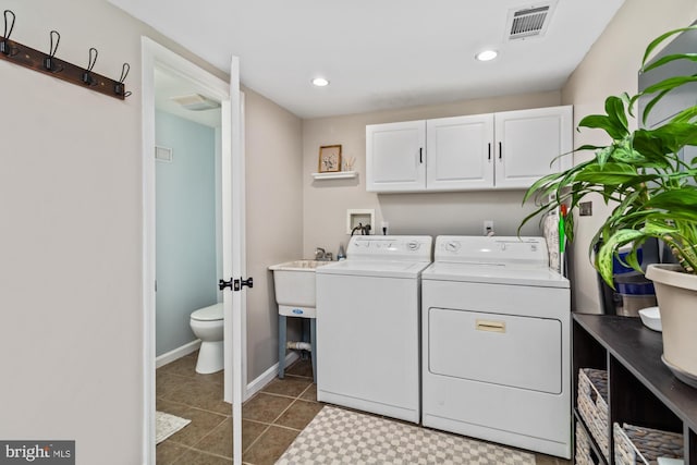 clothes washing area with washing machine and dryer, sink, and tile patterned floors