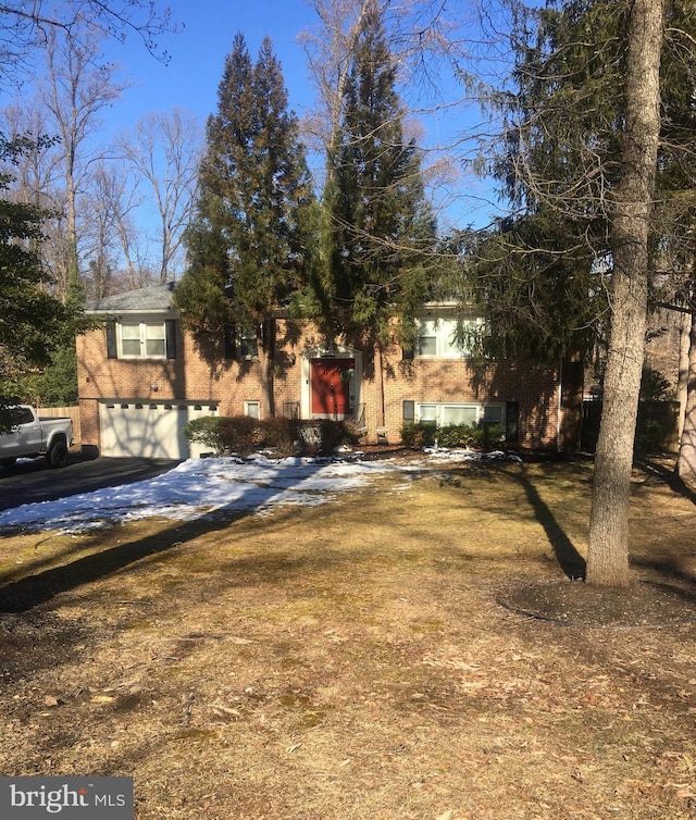 view of front of property with driveway, a garage, and brick siding