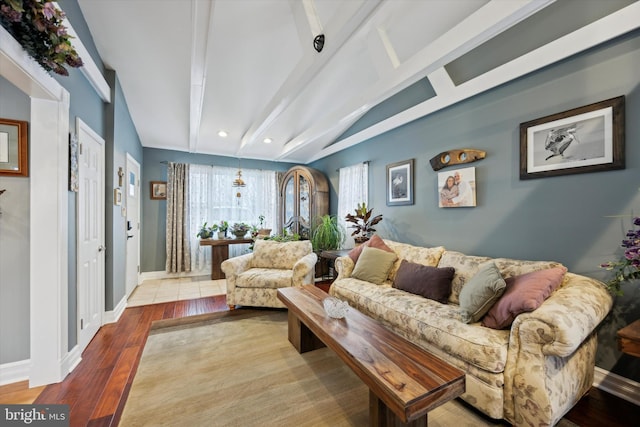 living room with vaulted ceiling with beams and light hardwood / wood-style floors