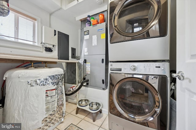 laundry room with stacked washer and dryer, electric panel, and light tile patterned flooring