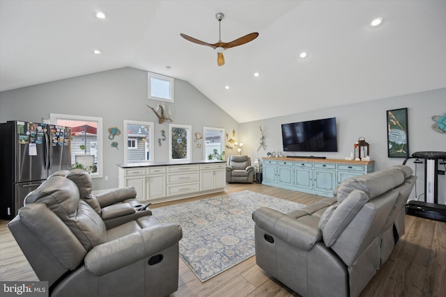 living room featuring vaulted ceiling, ceiling fan, and light hardwood / wood-style floors