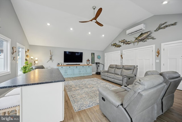 living room with ceiling fan, high vaulted ceiling, light hardwood / wood-style flooring, and an AC wall unit