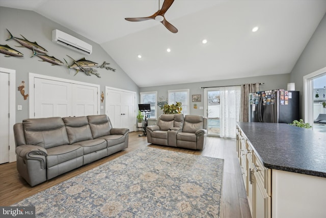 living room featuring ceiling fan, lofted ceiling, light wood-type flooring, and a wall unit AC