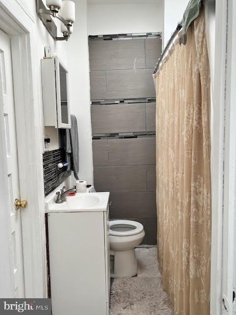 bathroom featuring a shower with curtain, vanity, and toilet