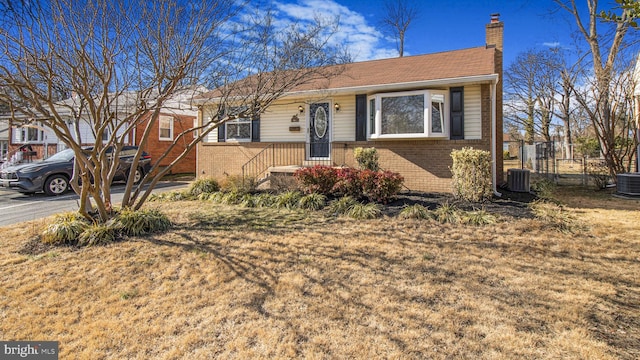 view of front of property with a front yard and central AC unit