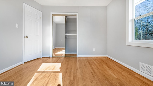 unfurnished bedroom with hardwood / wood-style flooring and a closet