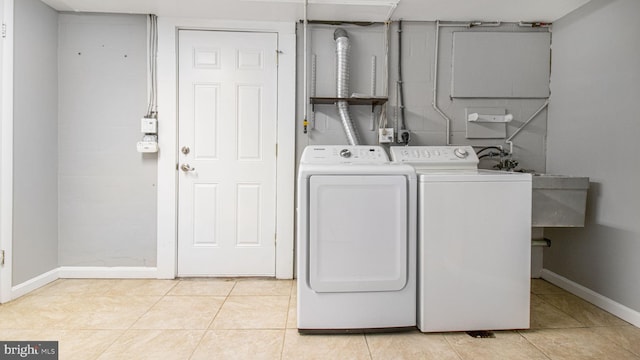 laundry room featuring washing machine and dryer and light tile patterned floors