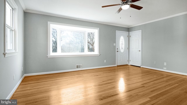 empty room featuring crown molding, light hardwood / wood-style flooring, and ceiling fan