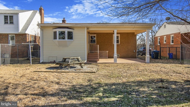 back of property with a lawn and a patio