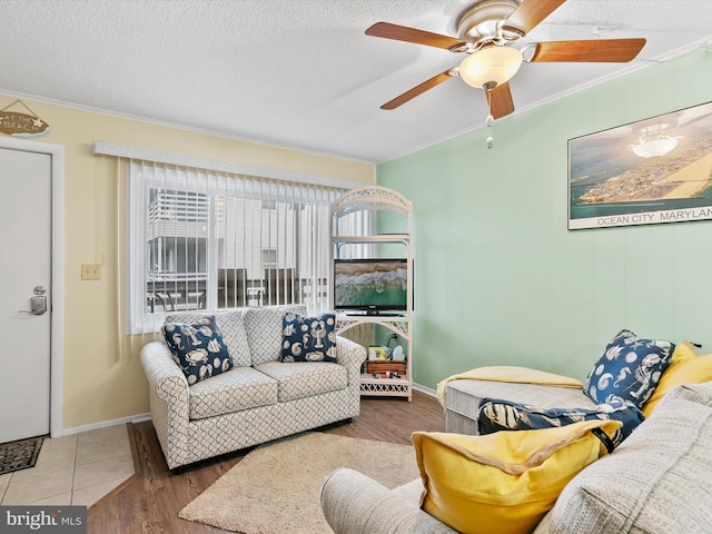 living room featuring crown molding, ceiling fan, hardwood / wood-style floors, and a textured ceiling