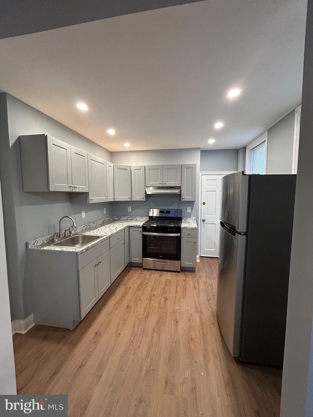 kitchen featuring stainless steel appliances, sink, light hardwood / wood-style floors, and gray cabinets