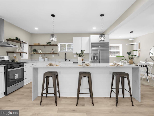 kitchen with white cabinetry, appliances with stainless steel finishes, and a kitchen breakfast bar