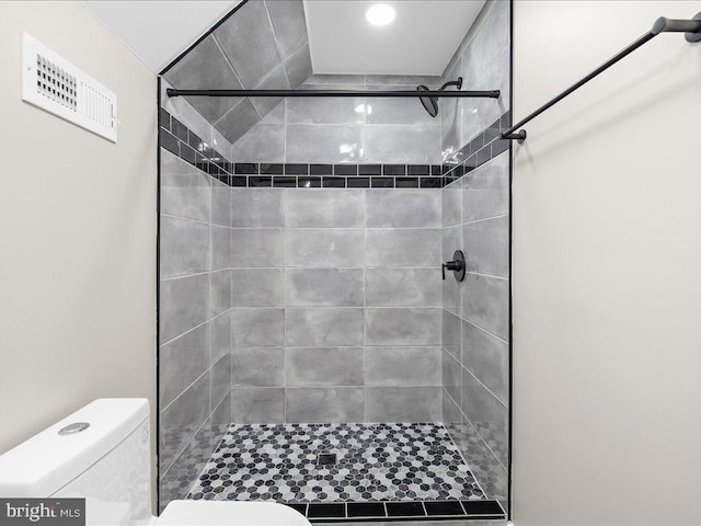 bathroom with tiled shower and toilet