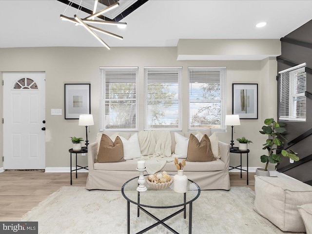 living room with a chandelier and light wood-type flooring