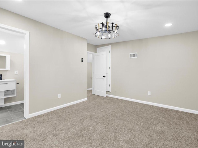 interior space featuring a notable chandelier, ensuite bathroom, and carpet flooring