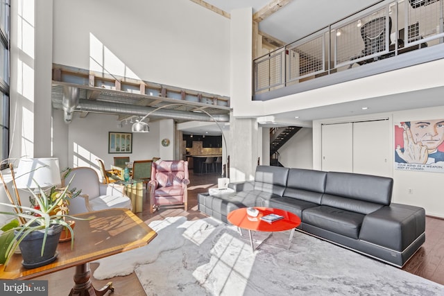 living room featuring a towering ceiling and dark hardwood / wood-style flooring