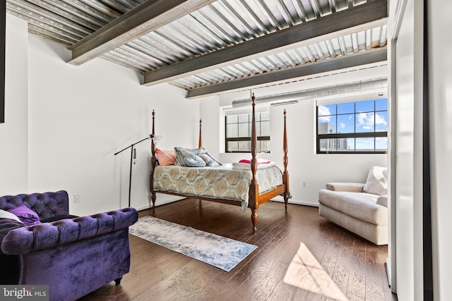 bedroom featuring beam ceiling and dark hardwood / wood-style flooring