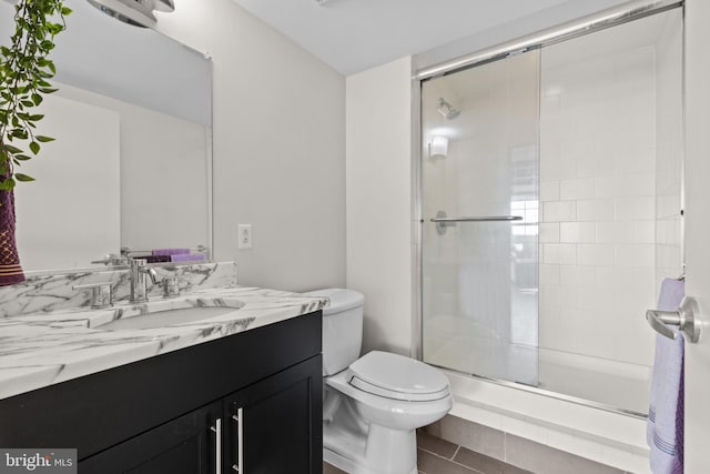 bathroom with vanity, toilet, and a shower with shower door