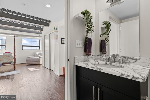 bathroom with wood-type flooring, beam ceiling, and vanity