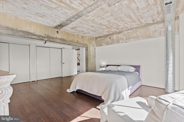 bedroom featuring two closets and hardwood / wood-style floors