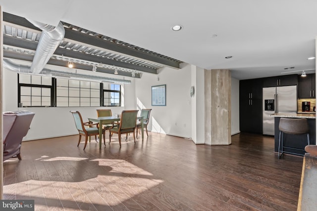 dining space featuring dark hardwood / wood-style flooring and beam ceiling