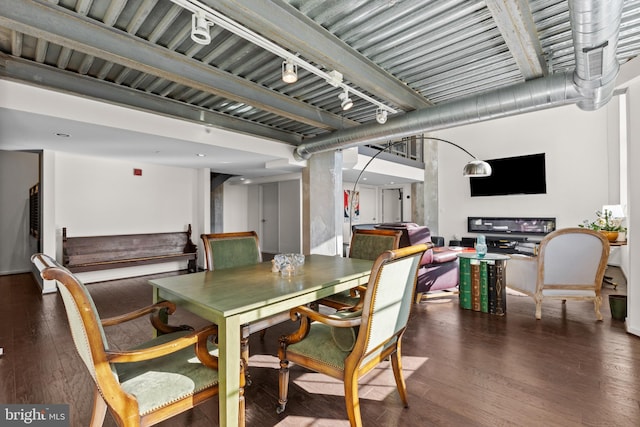 dining space with track lighting and dark hardwood / wood-style flooring