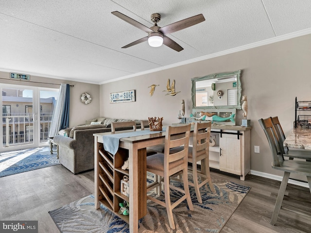 dining space with a ceiling fan, dark wood-style flooring, crown molding, and a textured ceiling