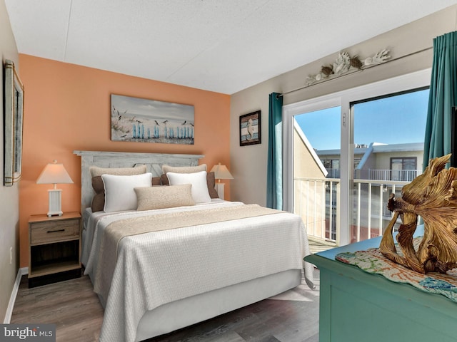 bedroom featuring a textured ceiling, baseboards, and dark wood-type flooring