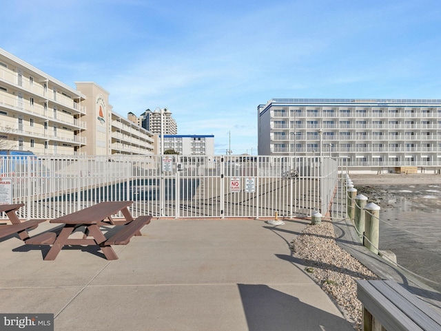 view of home's community featuring fence and a city view