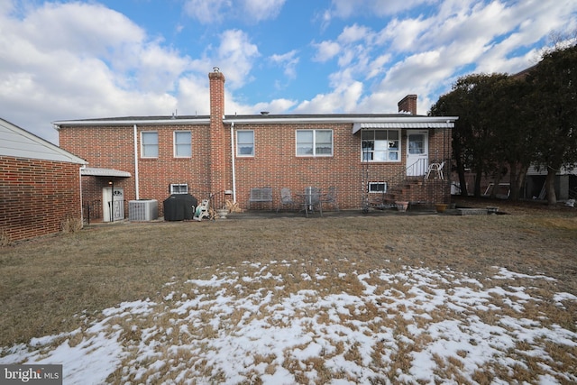 snow covered rear of property with central air condition unit