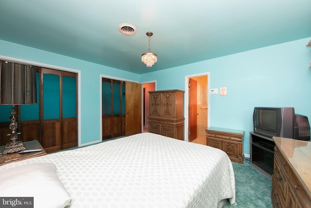 bedroom with multiple closets and carpet flooring