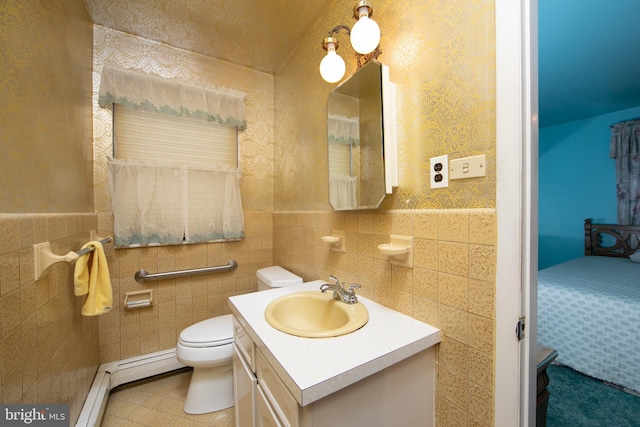 bathroom featuring vanity, tile walls, and toilet