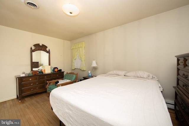 bedroom featuring dark hardwood / wood-style flooring and a baseboard radiator