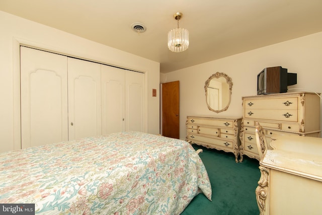 bedroom with a notable chandelier, a closet, and carpet flooring