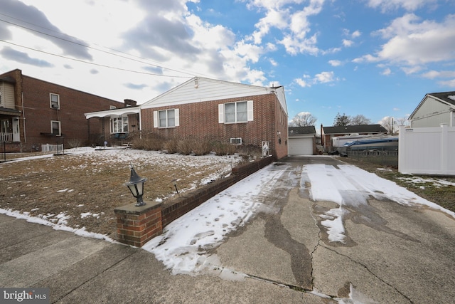 snow covered property featuring an outbuilding and a garage